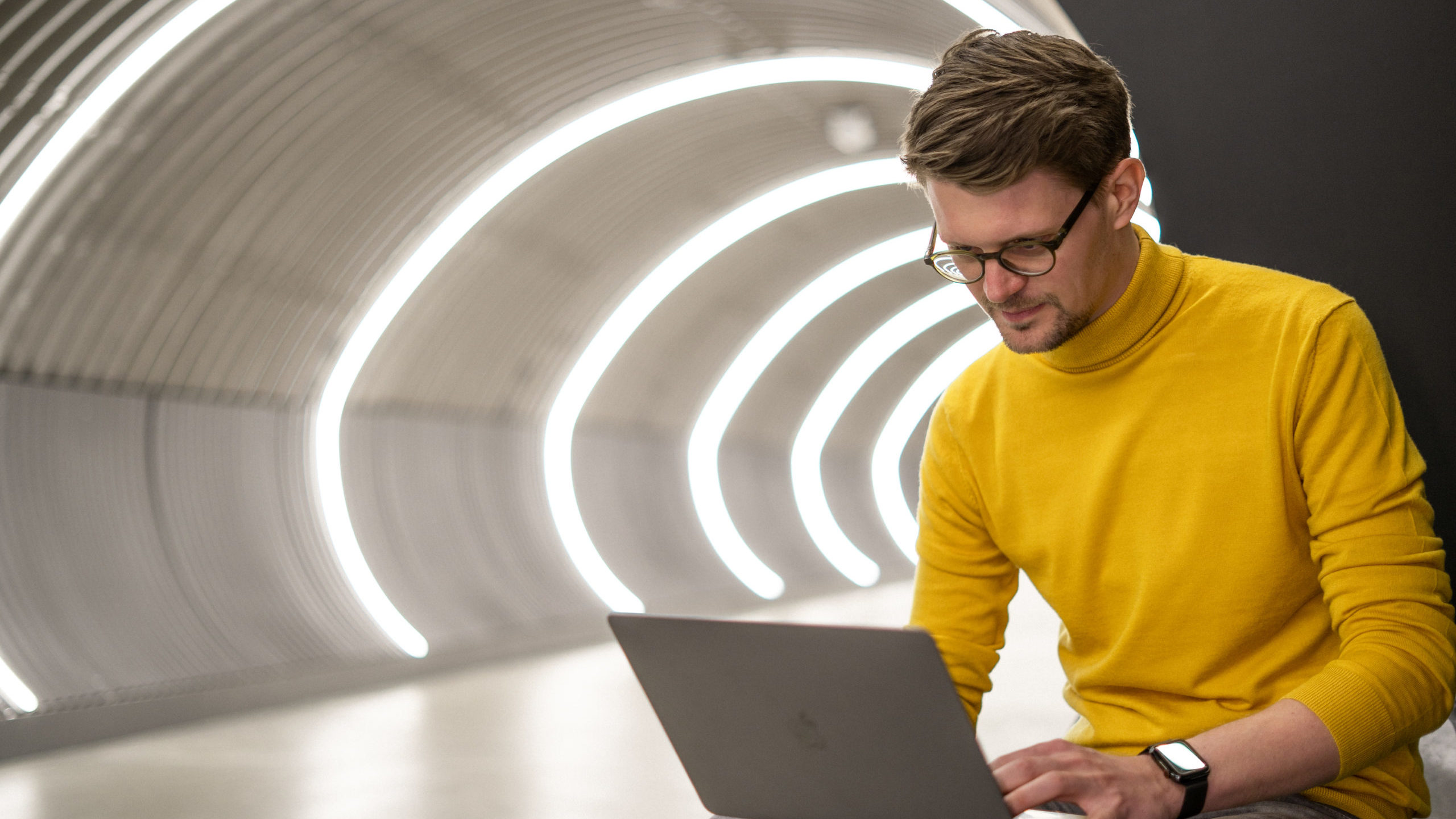 Porträt von Konrad Weber am Laptop arbeitend.